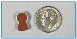 Size 312 Battery with Brown tab next to dime